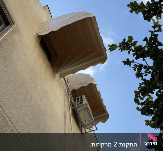 שני סוככים על קיר בניין עם שמיים כחולים